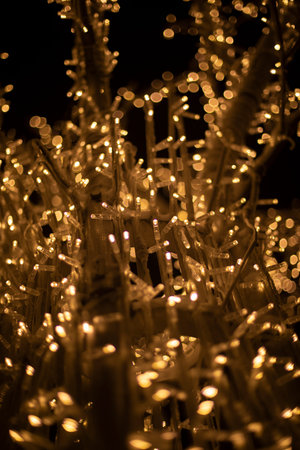 Lights in dark. Tree made of light bulbs. Christmas decorations in the city. LEDs are yellow. Lots...