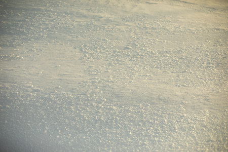 Texture of snow. Background is snowy plain. Details of winter.