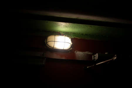 Lamp in entrance. duty light. Bad equipment. Twilight. Darkness due to weak light source.の写真素材