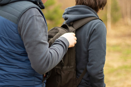 The guy is in a backpack. A man takes things from a friend's bag. A hacker passes something into a...