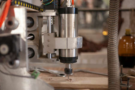 Milling runner cuts plywood. Sawing part with automatic tool. equipment in production. Head mounted blade for solid materials.の写真素材