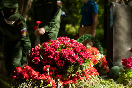flowers on grave. Military lay flowers on grave of soldier. Details of ceremony. Military men in dress uniforms.の写真素材