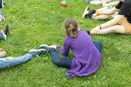 Teenage girl sits on green lawn. girl in the park. Rest on summer dayの写真素材