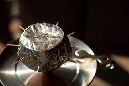 Foil on hookah. Ignition of coals in hookah. Smoking is harmful to health. Ash bowl.