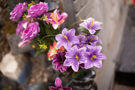 Flowers made of plastic. Artificial flowers for grave. Details of design of memorial.