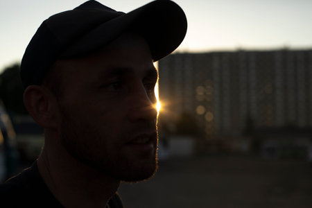 Guy in cap at sunset. Man on street. man's head.の写真素材