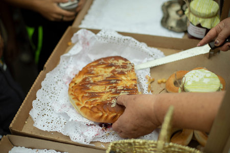Delicious pie on street. sweet food. Grandmother cuts pastries with knife. food in park.