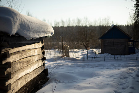 Winter in Russia. Snow on roof of hut. Old house made of wood. Wall of logs.の写真素材