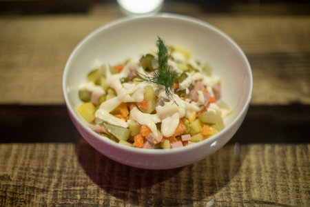 Salad with mayonnaise. Salad in plate. Olivier on table. Food from vegetables and meat.の写真素材