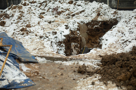 Pit for laying heating pipes in winter. Dug frozen ground in yard. Sewerage in north. construction work.の写真素材