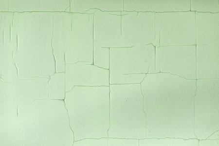 Cracks in paint. Old paint on wall. Fine mesh of cracks on surface. green background.の写真素材