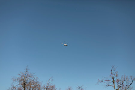 Small helicopter in blue sky. Aircraft. Helicopter flight over forest.の写真素材