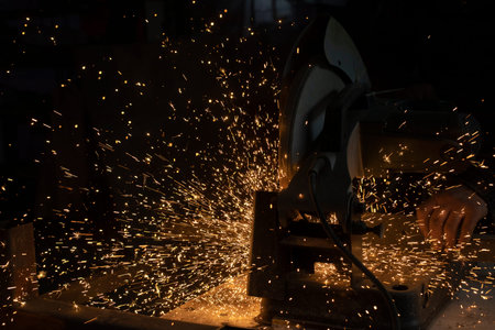 Sparks from metal. cutting steel. Saw spins quickly. industrial background. metal production...