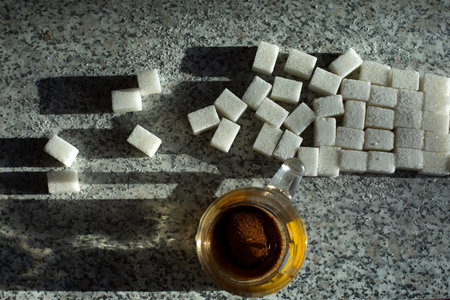 Sugar on table and tea. Lots of sugar pieces. junk food. breakfast details. white cubes.の写真素材