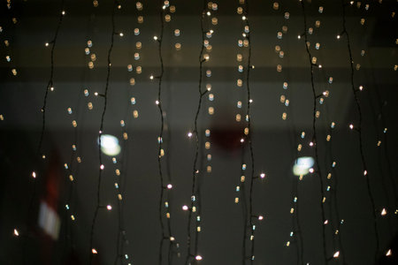 Garlands on glass. small lamps. LEDs decorate window.の写真素材