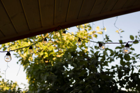 Light bulbs on the roof of the veranda. exterior details. Garland on edge of roof. decorating house.