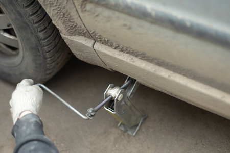 Jack lift car. Wheel replacement. Lever for lifting weights. Steel handle to increase pressure.の写真素材