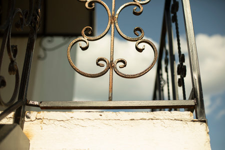 Steel fence on balcony. Forged steel in building. Decoration of facade of house. Bent metal.の写真素材