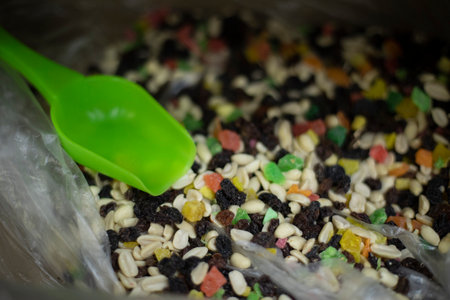Dried fruits on market. Delicious treat of natural products. Spatula for sweets. Box with crumbly nut mixture.の写真素材