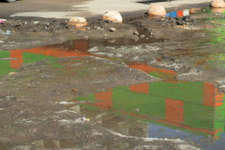 Dirt on road. Puddle in parking lot. Dirty street in city. Parting snow.の写真素材