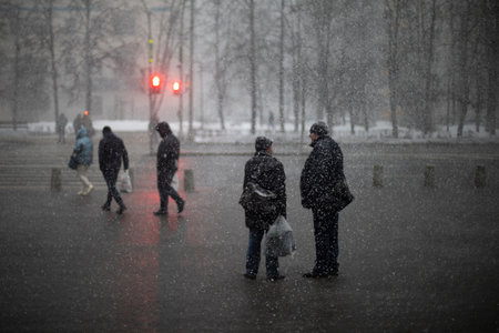snow outside. snowfall in city. people in wet weather. Snowflakes fly in the air.の写真素材