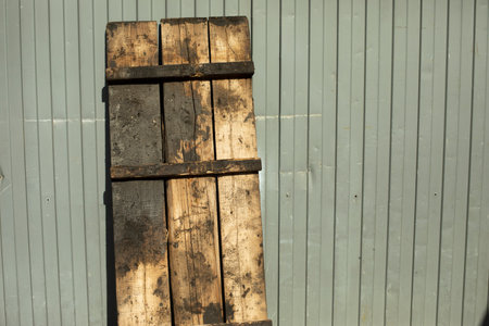 Pallet wood stands against wall. Details of industrial area. Dirty pallet. wooden bench.の写真素材