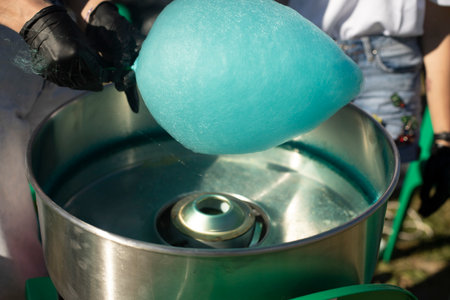 Cotton candy outside. Blue cotton candy on stick. sugar product. Delicious food. Details of preparation treat.の写真素材