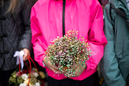 Bouquet of flowers in hands of child. Flowers for holiday. Details of holiday at school. Bouquet of...