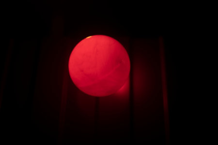 Red ball in dark. Signal lamp on fence. Light in dark.の写真素材
