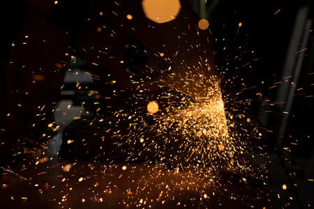 Sparks from grinder. metal cutting. Bright lights in dark. industrial background. Details of steel production.の写真素材
