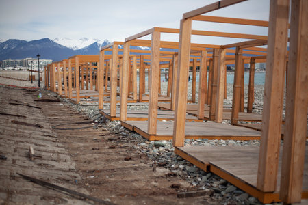 Construction of fair on embankment. Wooden construction of boards. Repair of market in city on seashore.の写真素材