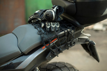 Motorcyclist's gloves are on trunk. Motorcycle is in detail. Summer season for biker.の写真素材