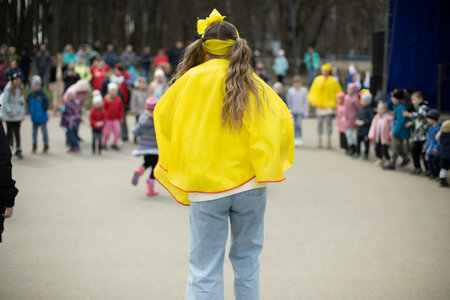 Girl entertain children in square. City holiday park. Animator entertains children on street.