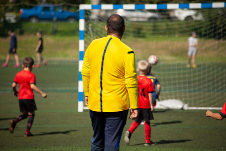Coach of children's football team. Children's play football. sports. Details of match.の写真素材