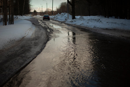 Wet road. Puddle on pavement. water on highway. Car left on road.の写真素材