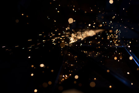Sparks in dark. Stream of lights on black background. Metal crushing. high temperature. Steel particles fly.の写真素材