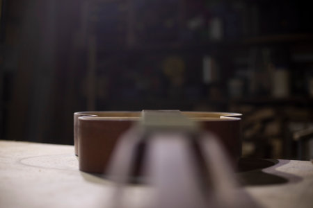 Old guitar on table. Acoustic guitar repair. Details of wood workshop. wooden musical instruments.の写真素材
