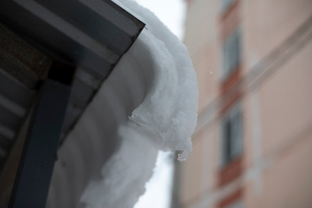 snow on roof. Roof canopy with ice. Snow on building. Details of icy edge.の写真素材
