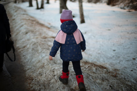 child in warm clothes. Preschooler walk alone. Child walks down street. Children in urban environment.の写真素材