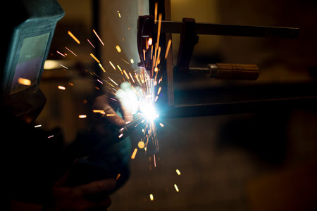 Welding work on metal. Blue fire from high temperature. Creation of welding seam. Sparks from temperature.の写真素材