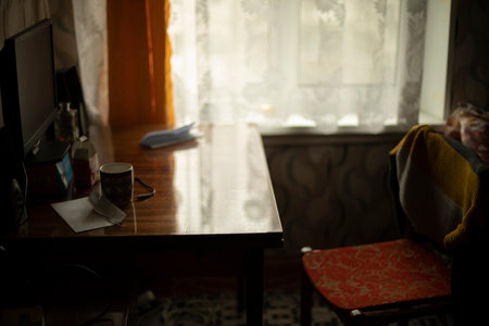 Table and chair. Interior of old apartment in Eastern Europe. Simple interior of house. Wooden furniture in house.の写真素材