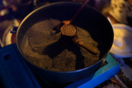 Coffee on sand. Making coffee at festival. brown foam. heating grains. hot sand.の写真素材