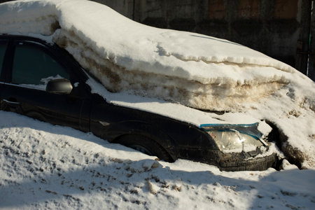 car under snow. In winter in parking lot. Transport after snowfall. Machine under infusion of ice. Ice float on body.の写真素材