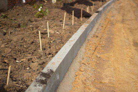 New messes on road. Repair of roads. Details of construction work. Concrete blocks are fixed in ground. Background construction sites.a.の写真素材