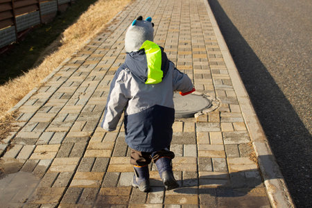 child runs down road. boy on street. Warm clothes on baby. Walk on windy day.の写真素材