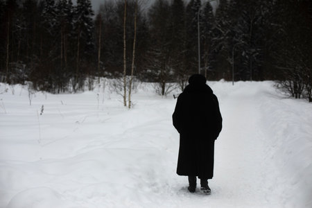 Woman walks through park in winter. Pensioner walks in winter. Details of walk on cold day.の写真素材