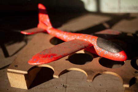 Toy airplane made of lightweight material. red plane. Children's toy on table. Abandoned thing from...