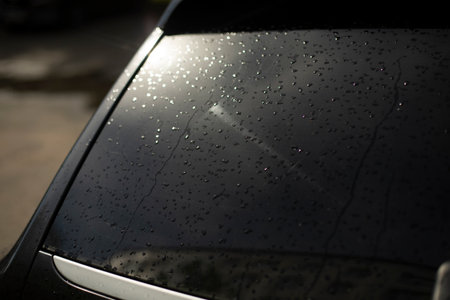 Black car rear window. Drops on rear window of transport. light on car window. Black Machine Parts.の写真素材