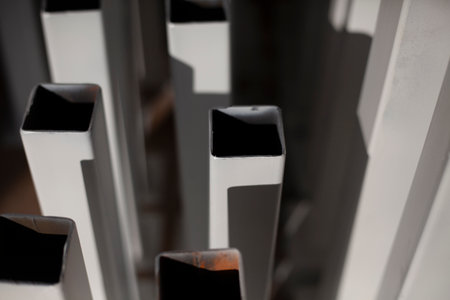 Painted steel profile. Steel product covered with white paint. Lots of metal parts. Parts of design made in workshop. white objects.の写真素材