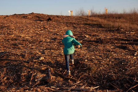 child runs through forest clearing. Little girl in empty space. Deforestation in Russia. environmental disaster. girl and nature.の写真素材